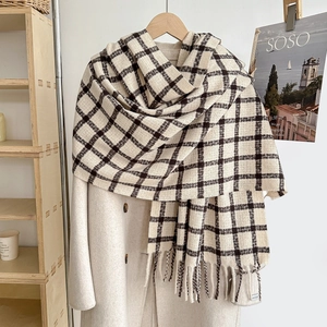 Thick checkered cashmere-feel scarf with tassels draped over a wool coat for winter