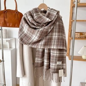 Close-up of brown and white checkered cashmere-feel scarf with elegant fringe detail