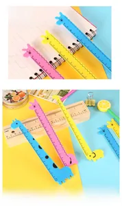 Detail of 15cm cartoon giraffe flexible rulers in blue, yellow and pink on a notebook
