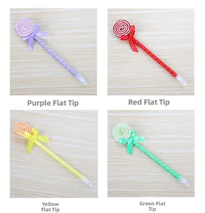 Detailed view of colorful lollipop pens with polka dots and bowties on wooden surface