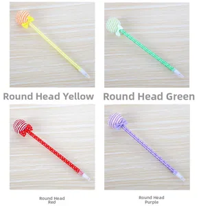 Detail of colorful lollipop ballpoint pens with bows and patterns on a wooden surface