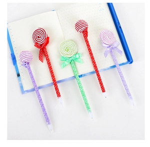 Close-up of candy-shaped ballpoint pens with polka dot patterns and ribbon bows
