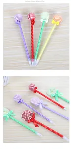 Detailed view of colorful lollipop ballpoint pens with polka dot bows on wooden background