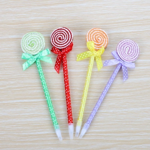Set of four lollipop-shaped ballpoint pens in vibrant colors on a wooden surface