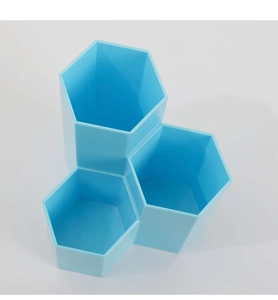 Close-up of sky blue hexagonal desk organizer with three tiered compartments for brushes