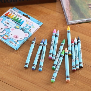 Detail of 12-color kids crayons in blue box with cartoon bear on a wooden desk