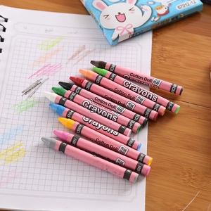 Close-up of multicolor crayons with paper sleeves on a wooden desk with a notebook