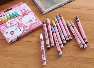 Detail of 12-color kids crayons with cartoon packaging on a warm wooden desk
