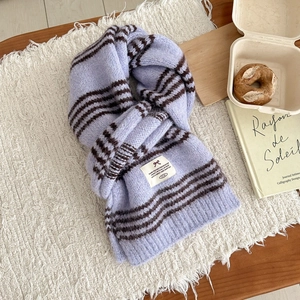 Close-up of soft purple striped knit scarf with a stylish bow woven label detail