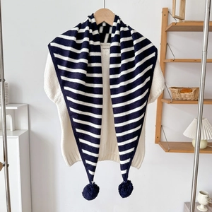 Détail de l'écharpe triangulaire en maille rayée bleu marine et blanc avec pompons