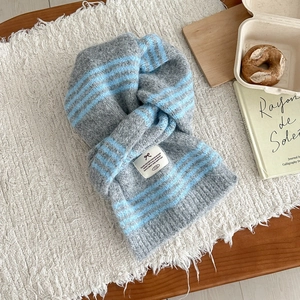 Thick grey and blue striped wool knit scarf with decorative label for winter warmth