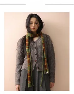Detail eines bunten Wollschals kombiniert mit dunkelbrauner Strickjacke und Rock
