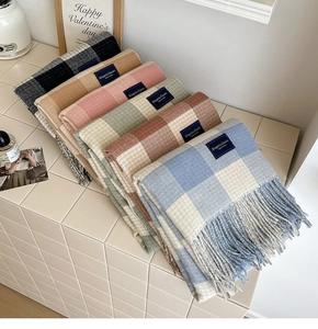 Detailed view of colorful plaid tassels scarves with elegant woven brand labels