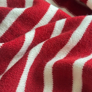 Détail macro du tricot à rayures rouges et blanches montrant la texture douce de l'écharpe