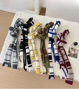 Flachbild von bunten gestreiften Strickschals auf weißem Fleece mit Lifestyle-Requisiten