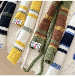 Detailansicht gestreifter Strickschals aus Wolle in verschiedenen Farben mit Qualitätslabel