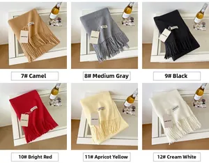 Detail view of wool scarf fringe in camel, grey, black, red, yellow and cream colors