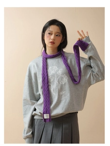 Detail of purple cable knit skinny scarf styled with a grey floral sweatshirt