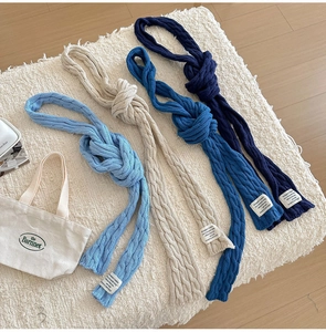 Detailed knit texture of solid color cable twist scarves in blue and beige tones