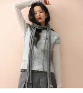Detail of grey knitted wool scarf paired with matching patterned vest in Korean style