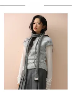 Detailed knit texture of a grey wool baguette scarf paired with a matching knitted vest