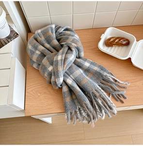 Détail d'une écharpe épaisse en laine à carreaux avec franges douces et motif classique