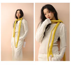 Detail of bright yellow knitted long scarf showing soft texture and minimalist Korean style