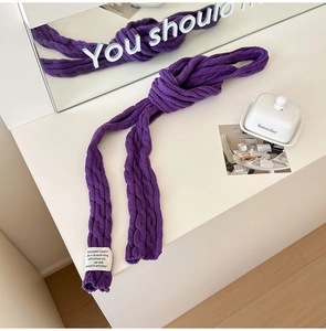 Detail of purple cable knit scarf showing soft texture and stylish white woven label