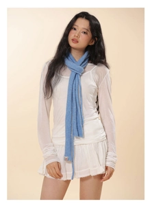 Detail of light blue narrow knitted wool scarf with rectangle brand label texture