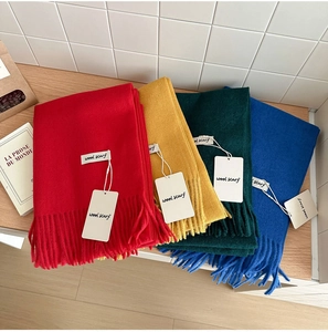 Detail of colorful wool blend scarves with fringes in red, yellow, green and blue shades