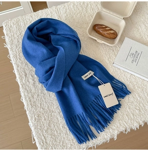 Detailed close-up of premium royal blue wool scarf texture with long fringe tassels