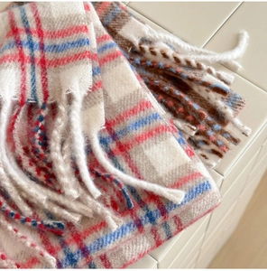 Détail de la texture d'une écharpe en laine à carreaux avec de longues franges souples