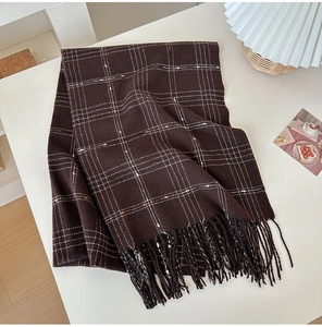 Close-up of brown plaid cashmere-like scarf with long fringe and white grid pattern