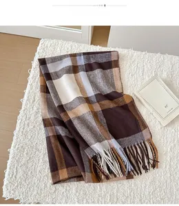 Macro detail of classic plaid scarf with fringe tassels on soft white plush surface