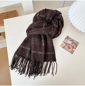 Close-up of brown plaid scarf texture with fringes and cozy vintage background
