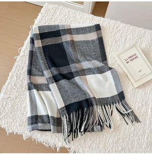 Detailed texture of black and white plaid scarf with soft tassels and book decor