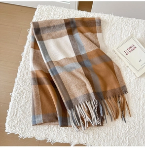 Detail of classic plaid scarf texture with soft tassels on cozy neutral background