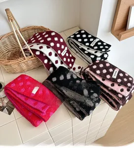Detailed knit texture of polka dot pattern scarves in multiple colors for winter