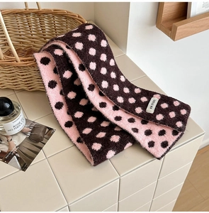 Detail of soft double-sided polka dot knit scarf with pink and brown woven texture