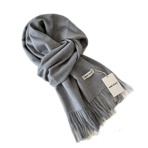 Soft grey wool scarf with classic fringe tassels and brand tag on white background