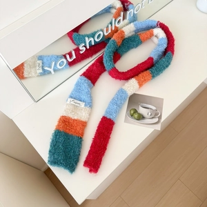 Macro detail of the colorful striped plush scarf showing texture and Vegetable woven label