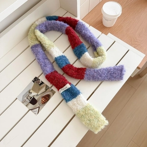 Close-up of rainbow striped knit scarf featuring thick colorful yarn and woven label