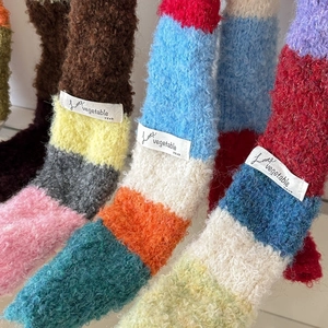 Detailed macro shot of colorful striped plush socks featuring Love vegetable text label