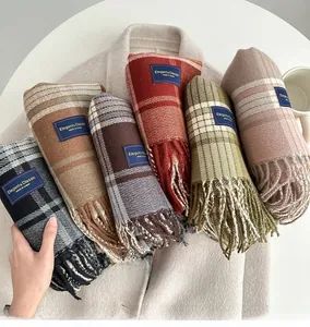 Groupe de six écharpes à carreaux avec pompons en plusieurs couleurs sur un manteau
