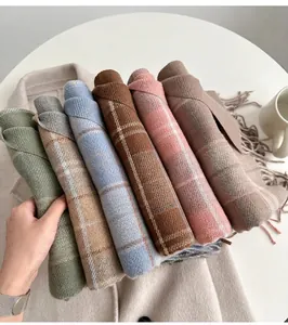 Gros plan de divers foulards à carreaux avec franges en plusieurs couleurs pour l'hiver