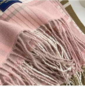 Gros plan sur le tissu d'écharpe à rayures roses et grises avec franges et étiquette