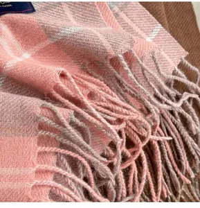 Vue détaillée de l'écharpe à carreaux rose et gris avec des finitions à franges