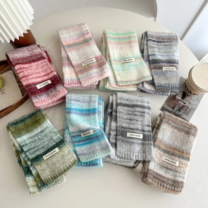 Huit écharpes en laine mélangée à rayures colorées disposées sur une table blanche ronde
