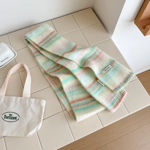 Détail de l'étiquette en laine et texture de tricot arc-en-ciel pastel sur l'écharpe