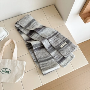 Détail de la texture d'une écharpe en maille rayée gris et blanc en mélange de laine